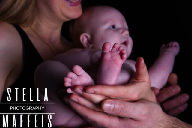 Babys feet being held by her parents hands.