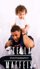 A curly haired toddler sitting on her dads shoulders.